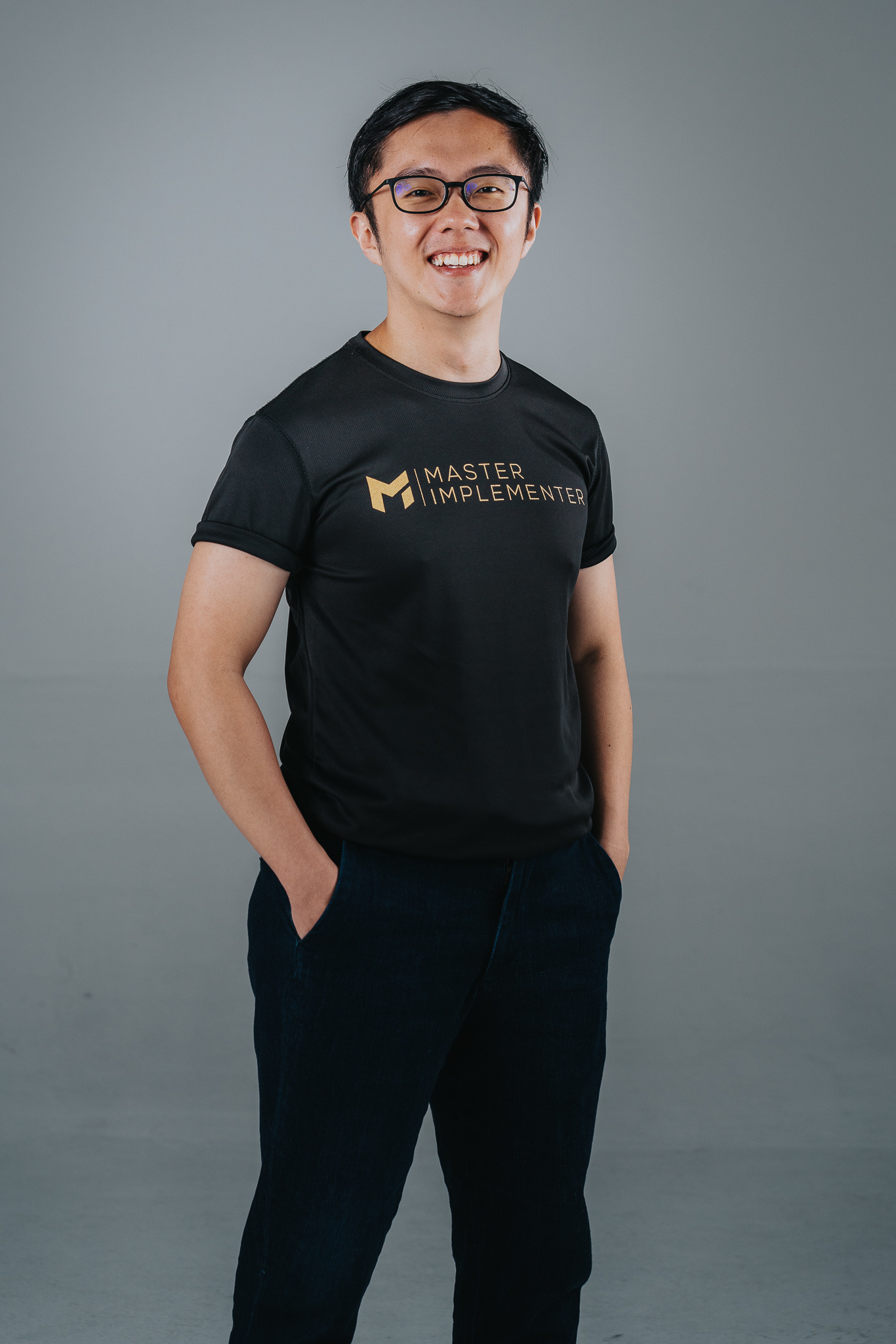 Full body studio shot on a grey background, wearing an MI tee.