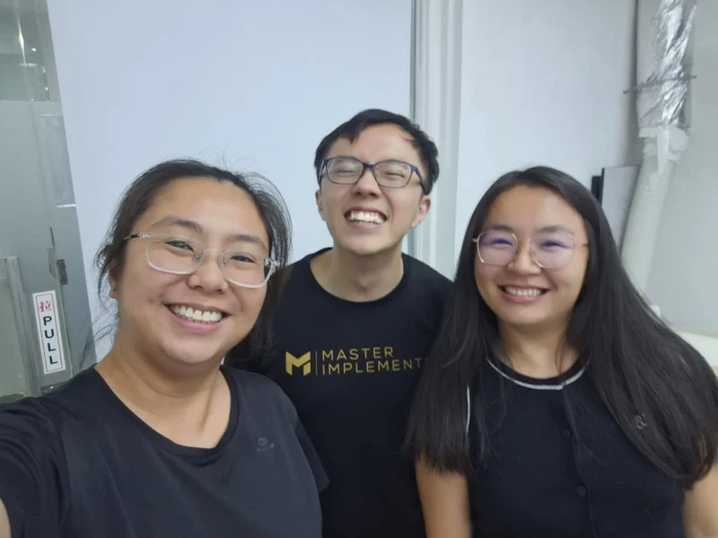 Marc with two community members, all wearing Master Implementer shirts.